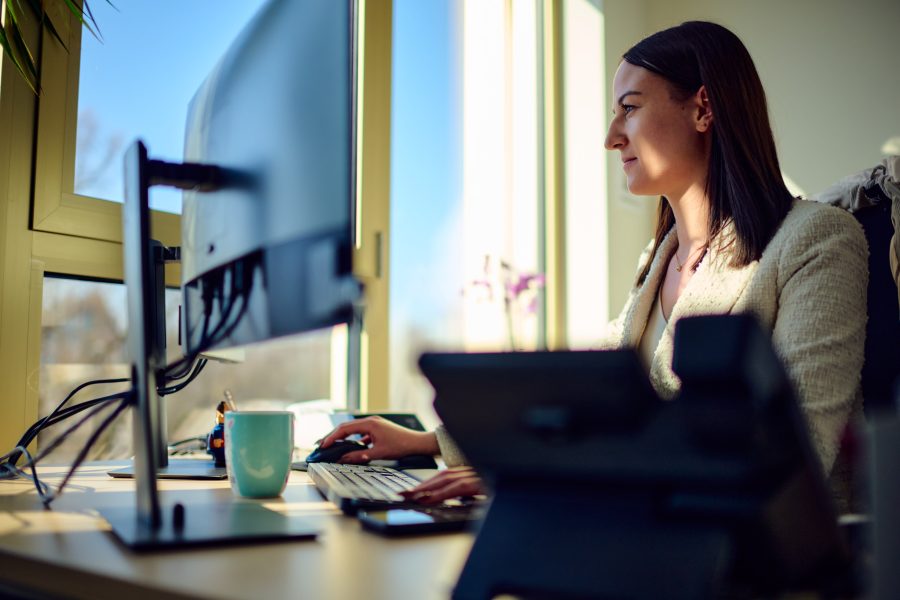Mitarbeiterin arbeitet am Schreibtisch